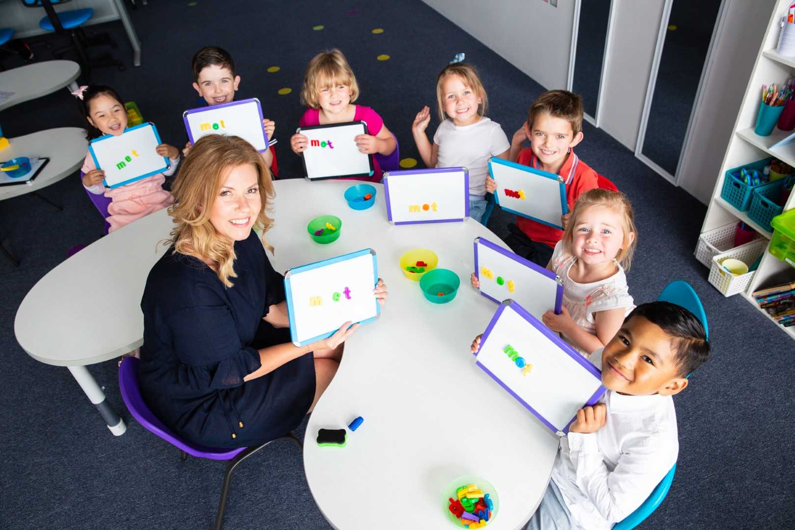ABC to VCE teacher with a small group of smiling students in class